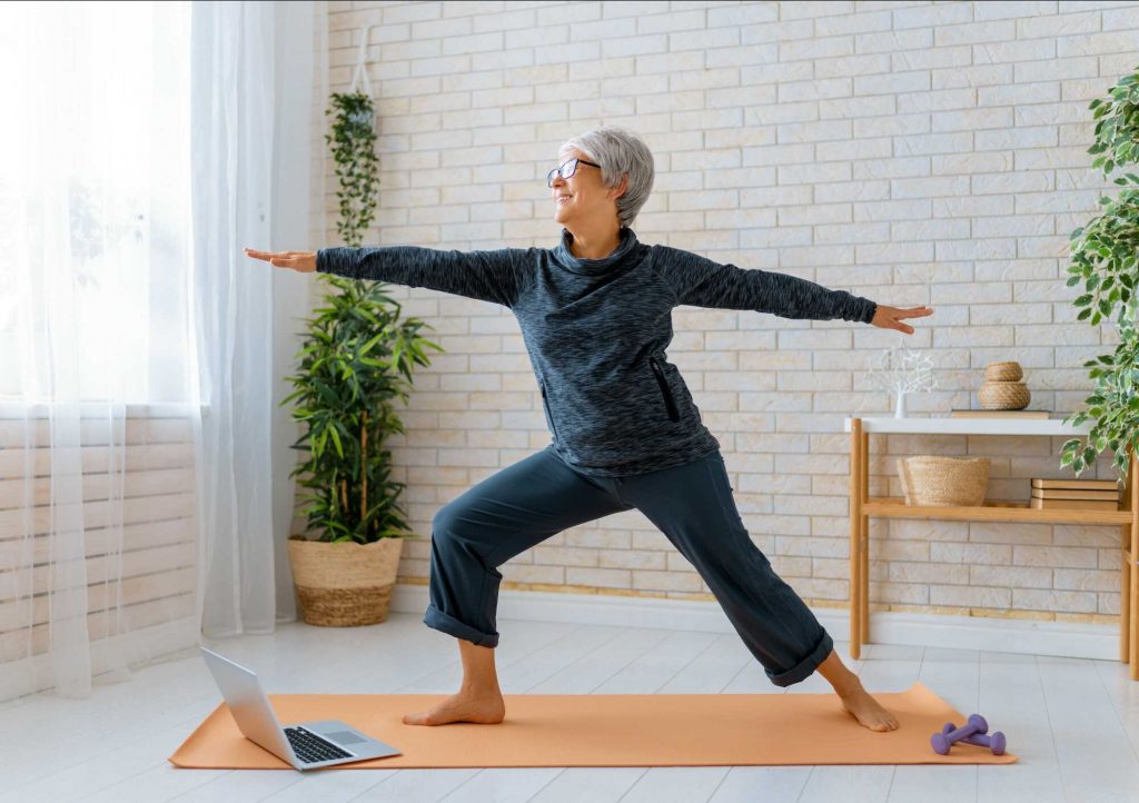 Žena, seniorka cvičí jógu doma na podložce